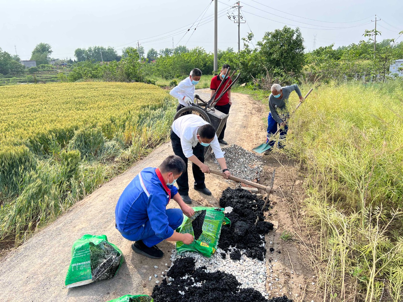 羅山服務區幫助屬地村民修補道路,方便夏糧收割機通行。張翔斐 攝.jpg